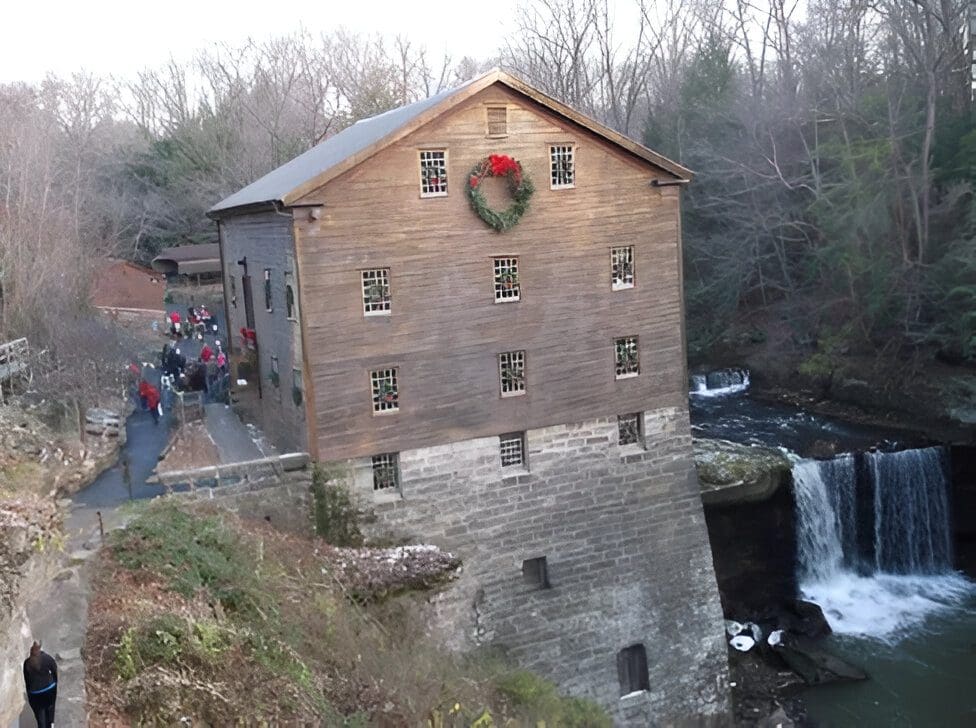 Christmas wreath on historic mill by waterfall.