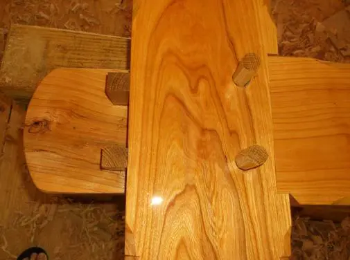 A wooden table with two legs and three small feet.