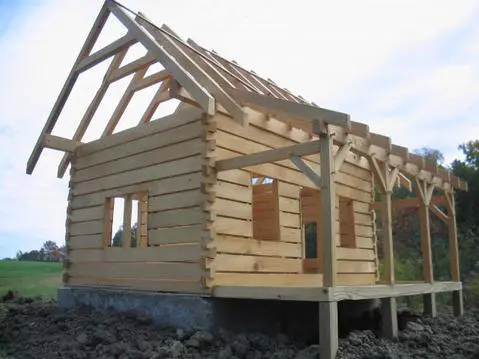 A log cabin with a wooden roof structure.