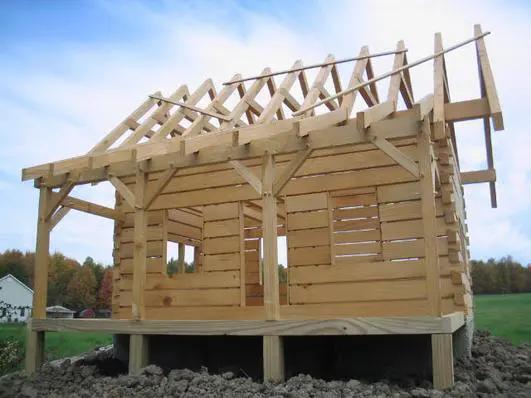 A log cabin with a wooden roof structure.