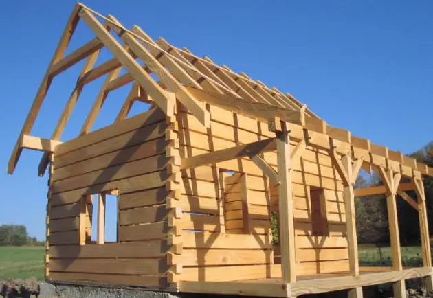 A log cabin with a wooden roof structure.