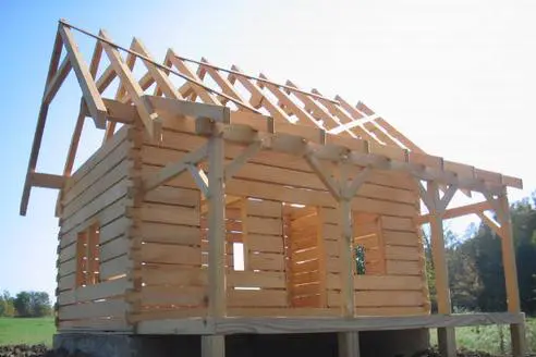 A log cabin being built with wooden beams.