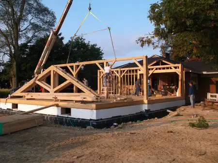 A wooden structure being built on top of cement.