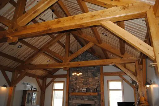 A room with wood beams and a fireplace.