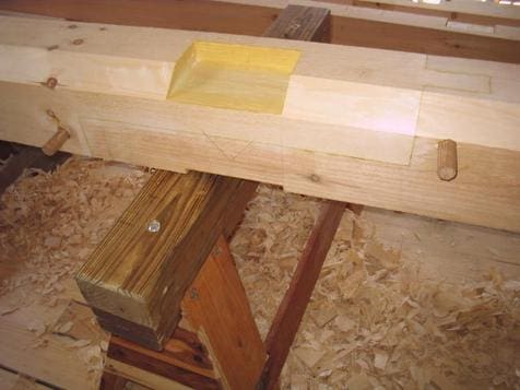 A wooden beam with some yellow tape on it